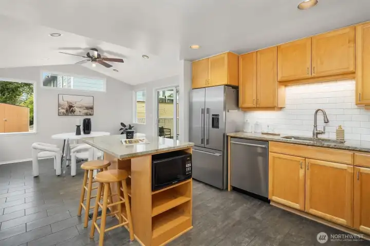 Open concept kitchen and dining with island seating and natural light Open concept kitchen and dining with island seating and natural light