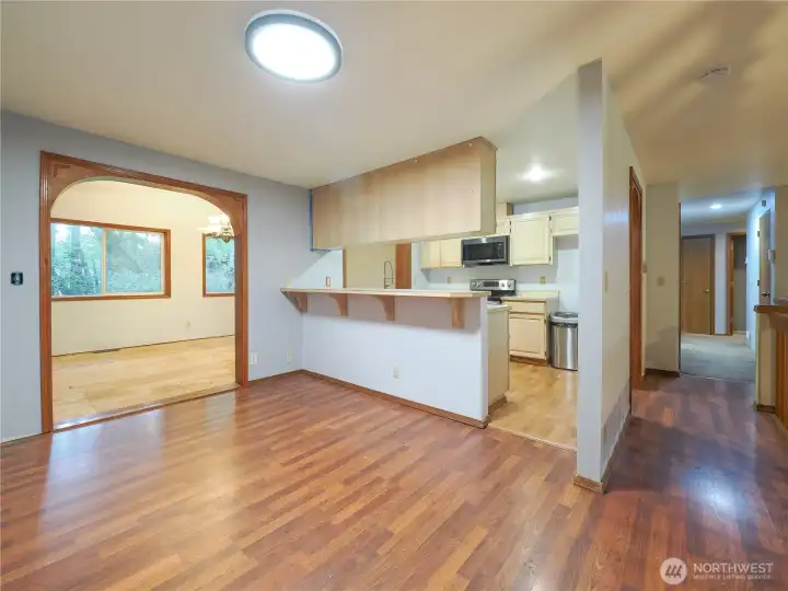 Casual dining room with formal dining room or rec room to the left and hallway leading to 3 bedrooms