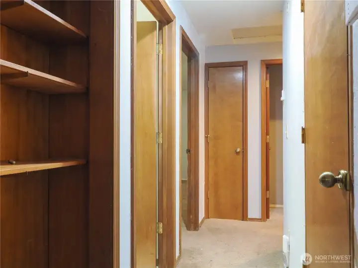 Top of the stairs hallway leads to primary and 2 bedrooms