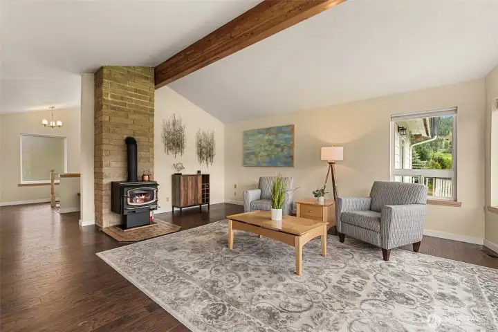 Anchored by a freestanding wood stove with brick surround, the room blends comfort and character with rich flooring and abundant natural light.