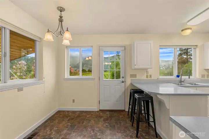Bright and functional kitchen and breakfast nook space with picturesque mountain views and direct access to the covered deck for effortless indoor-outdoor living.