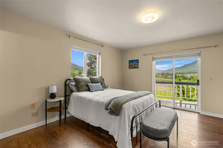 Spacious primary suite offering peaceful mountain and valley views, enhanced by abundant natural light and direct access to the outdoor deck