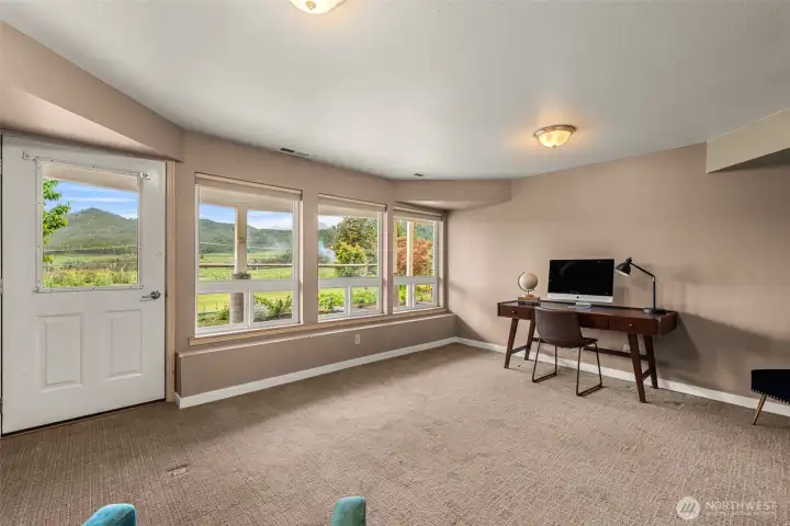 Expansive windows frame the surrounding mountain and valley views, filling this versatile living space with natural light and a strong connection to the outdoors.