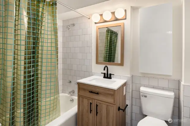 Updated bathroom with new tile, vanity and fixtures.