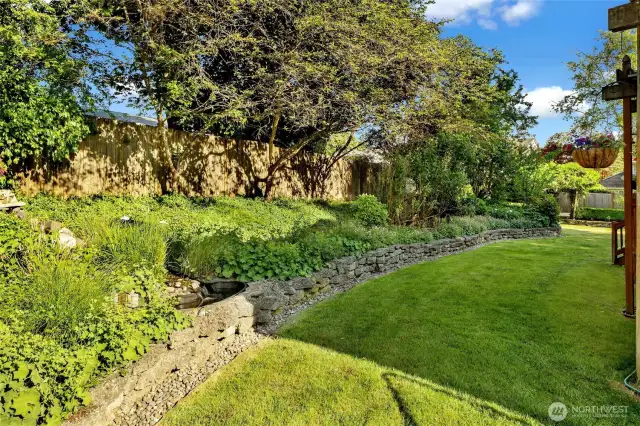 Elegantly manicured garden beds along the back of the house.