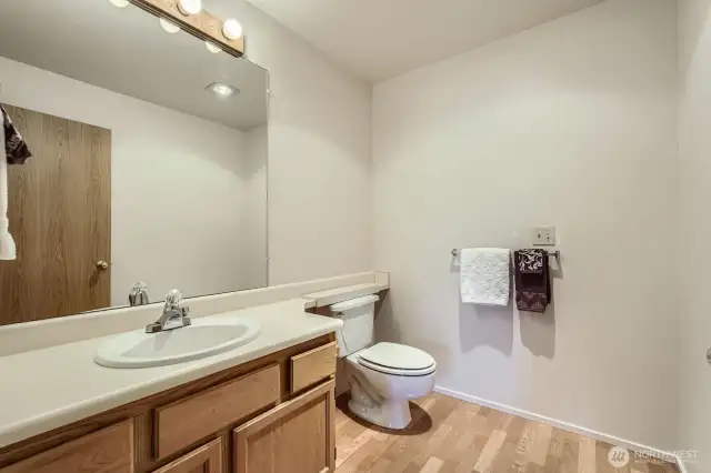 The half bath is perfect for guests and features attractive laminate wood floors.