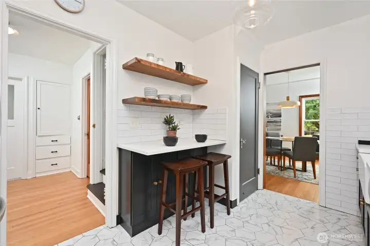 is central to the home with access to the dining room, back hallway, stairs to the lower floor and outside access to the side yard patio and deck.