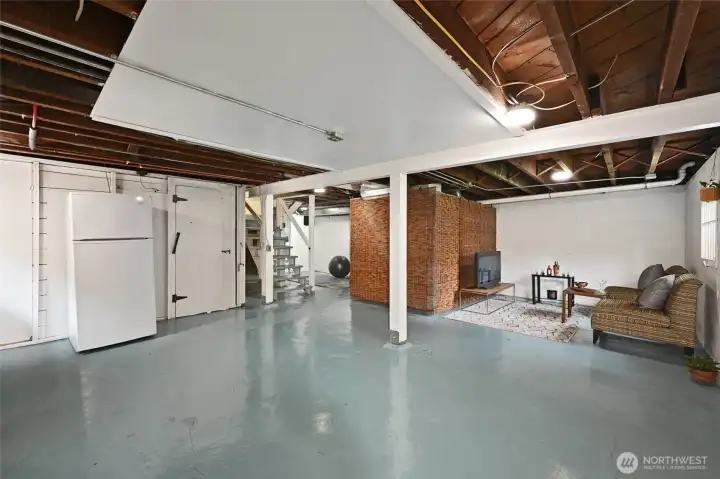 A light-filled space, with decent ceiling height has been staged as a rec room by the window to the back yard.   Separated from the furnace and hot water by bamboos screens, it creates a workout area space on the way to the large storage room with shelves.  There exists a lot of flexibility to transform and use this space in many different ways. The door by the refrigerator leads to the single car garage.