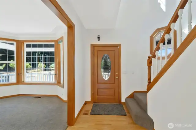Welcoming front entry with hardwood floors and a beautiful oval glass door. Adjacent room features a large bay window, perfect as a sitting area or home office.