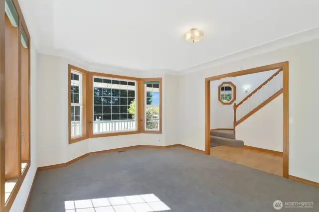 Versatile front room with charming bay windows and soft carpeting, ideal for a formal living space, reading nook, or sunlit retreat.