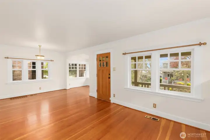 Craftsman details: gorgeous arch, thick moldings, solid door, wood floors, wood curtain rods, lovely light fixture and windows that surround your living area to give you a great view of nature.