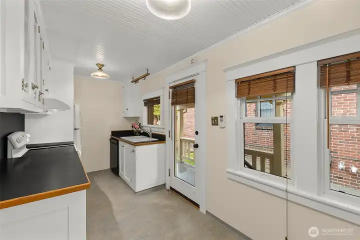 Light-filled, west-facing kitchen has large windows and space for kitchen table and chairs.