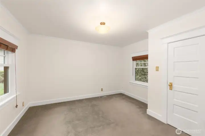 Bedroom has windows that oversee this home's lovely garden and patio.