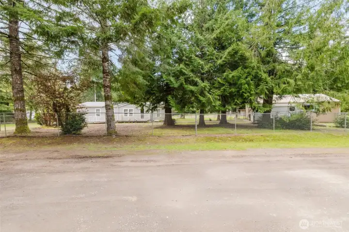 Street view, showing garage/SHOP off to the right of the home. Separate driveway leading to shop and RV parking.