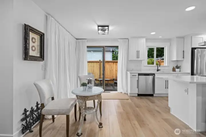 A sliding glass door off the kitchen area opens directly to the hydrangea-lined side yard — your own little escape.
