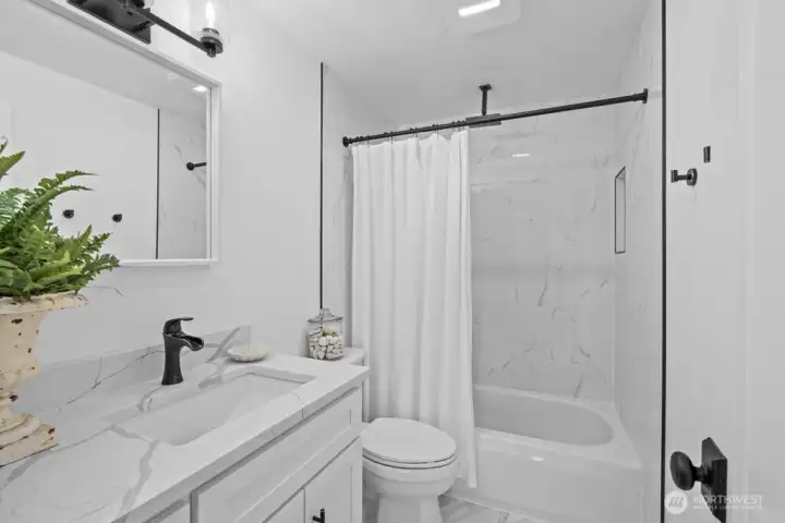 A full bathroom with dual shower options, rain showerhead, and a recessed shower shelf — spa-like in every way.