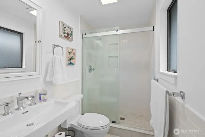 A serene ensuite bath with dual tiled shower niches — beautifully updated and finished with care.