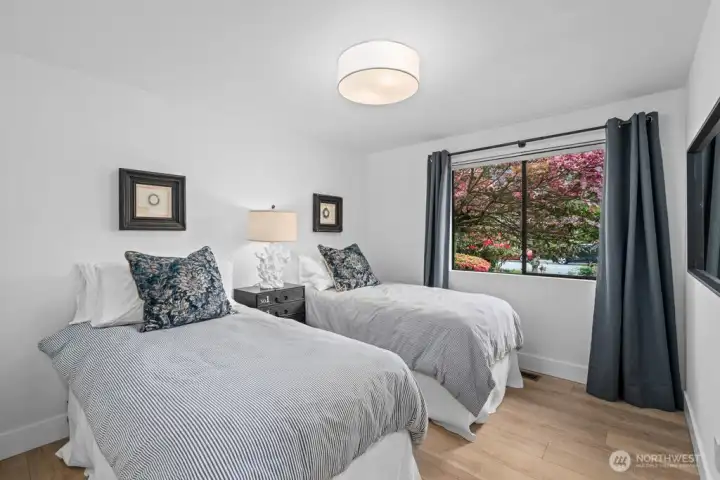 Bedroom 2 is filled with natural light, a custom closet, and a window perfectly framing the blooming dogwood tree outside.
