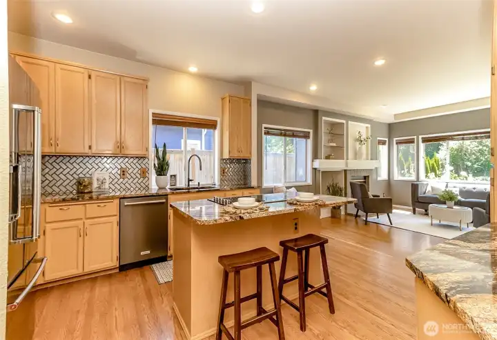 This Kitchen features granite countertops and SS appliances.  It opens to the family room with a cozy, gas fireplace....all with a tranquil view of the gorgeous backyard.