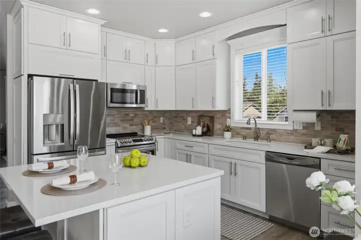 Gleaming white quartz counters and ceramic tile backsplash.