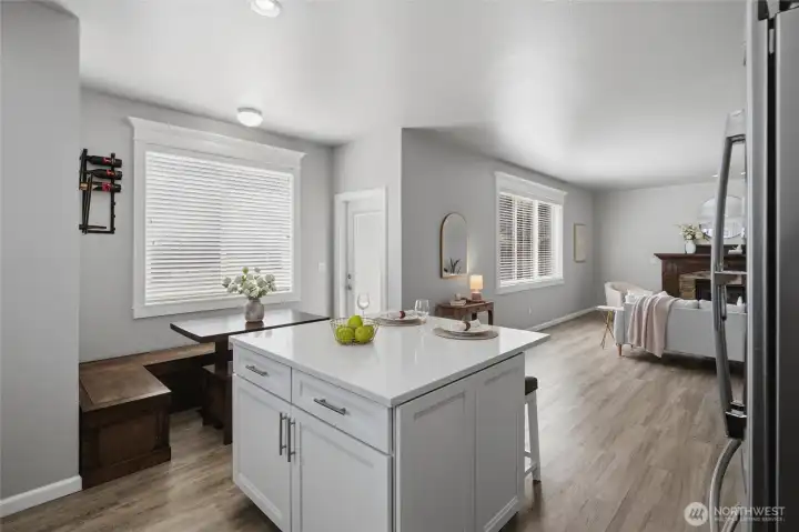 Kitchen island, breakfast nook, door to back yard and great room with fireplace.