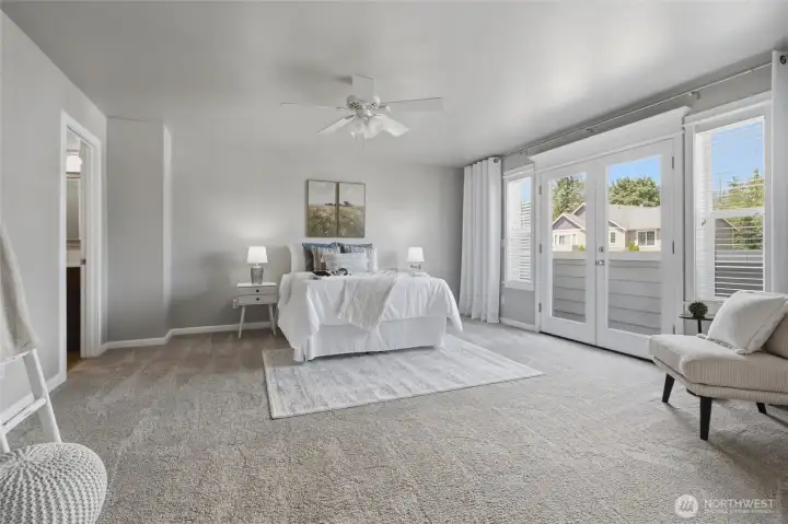 The primary bedroom is exceedingly spacious and features french doors opening to a balcony with a seasonal view to Puget Sound and Bainbridge Island.