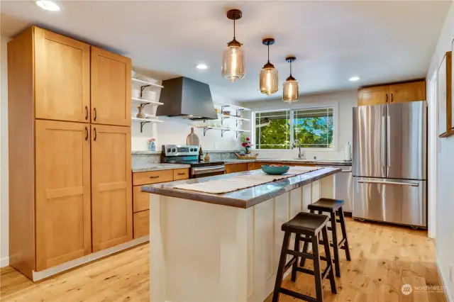 The eat-in kitchen features granite counters, a copper kitchen island with additional storage, a full set of appliances, and open shelving.