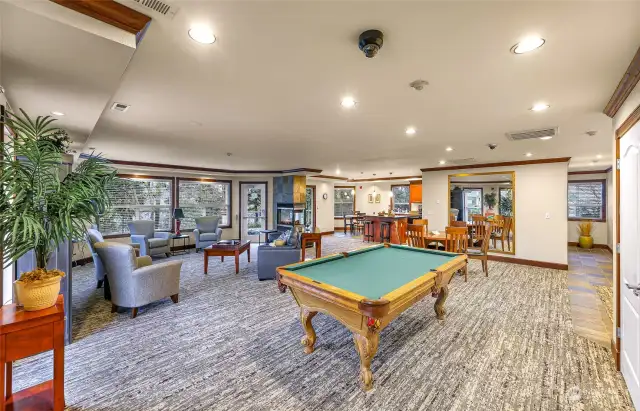 The clubhouse features a large seating area for meetings or gatherings, a pool table, TV, fireplace, games, etc.