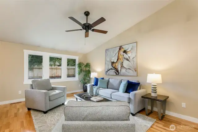 Large living room w/ vaulted ceilings & backyard views