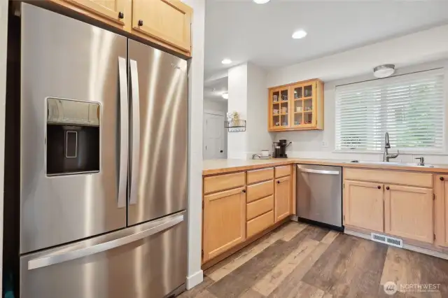 Kitchen features new appliances and glass cabinetry