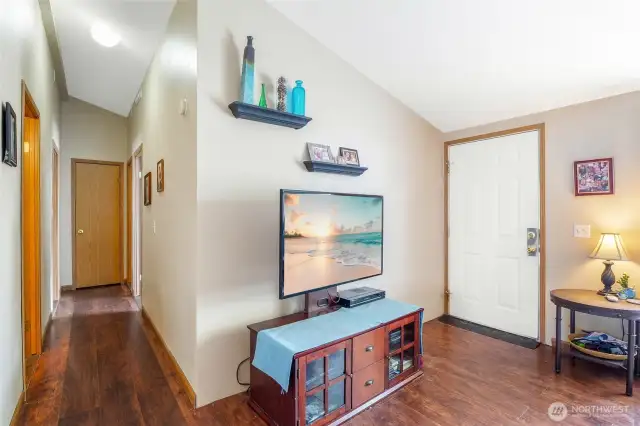 From the living room, you'll head down the hall to the bedrooms. The door on the right is the front door.