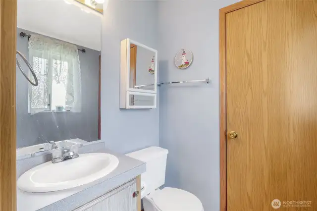 Half bath with doors to the kitchen and primary bedroom.