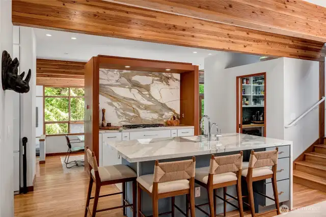 Remodeled kitchen with porcelain waterfall island and dramatic backsplash.