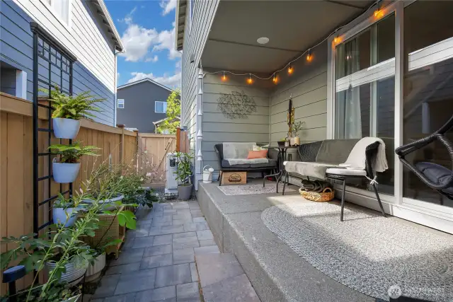 Covered patio to side yard finished with pavers and pea gravel