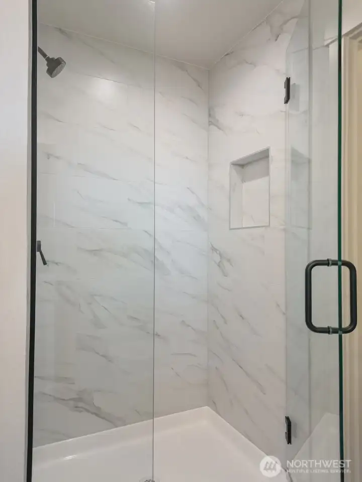 Primary Shower with floor to ceiling tile.