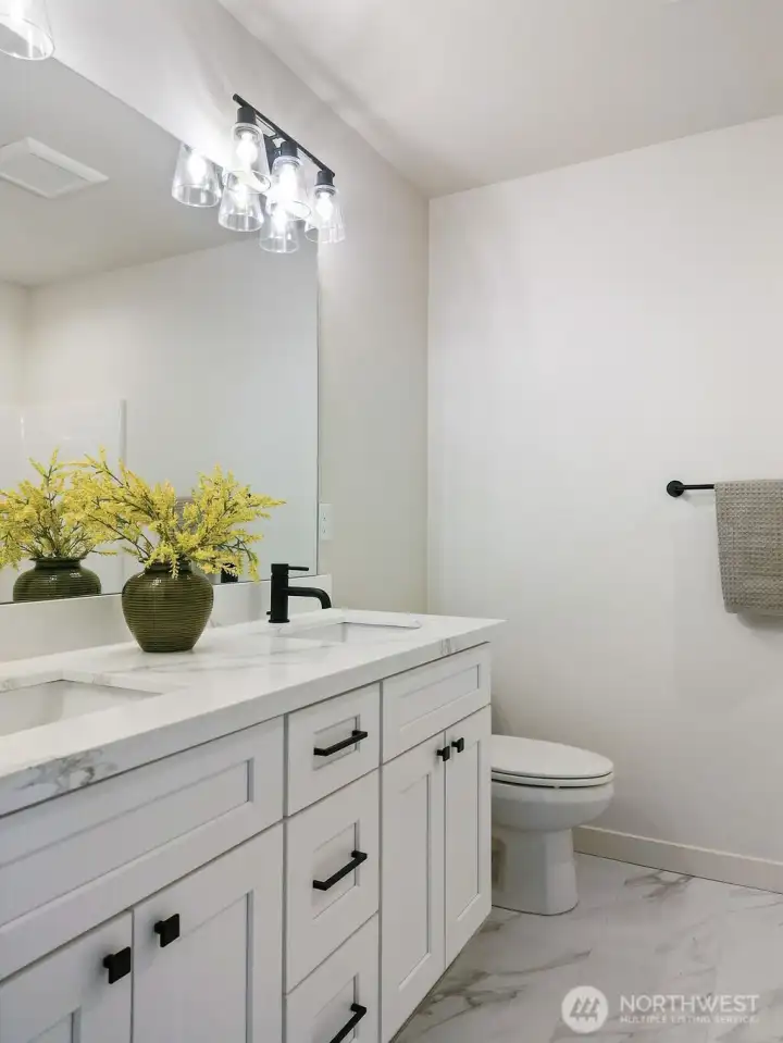 Main Bathroom has quartz counters and dual undermount sinks and lovely tile flooring.