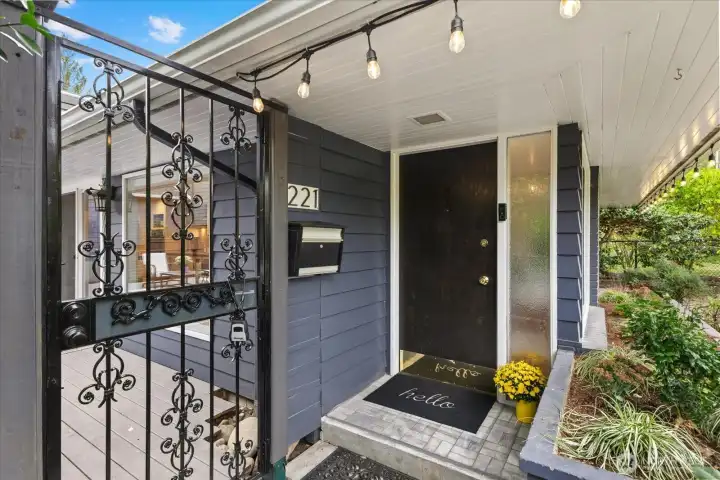 Cheery covered front entry and a locking secure gate greet you.