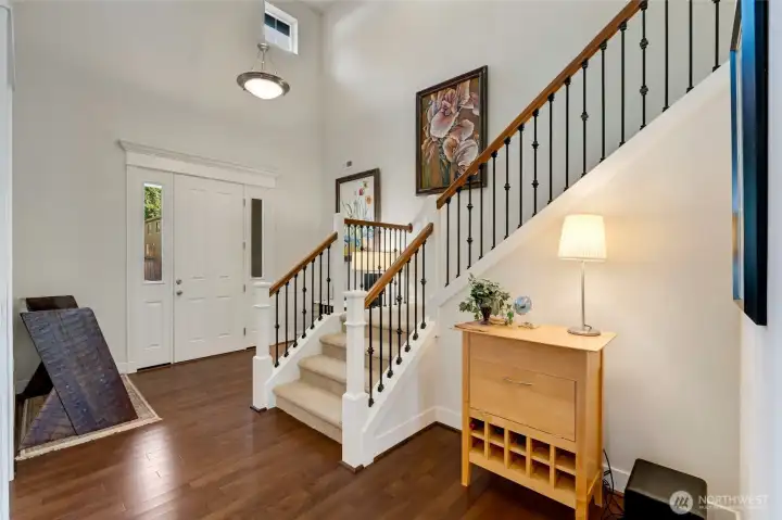 Inviting two-story foyer with natural light pouring in through high transom windows. Elegant iron spindles and warm hardwood floors set a welcoming tone the moment you enter. The space feels open, airy, and perfectly designed to make a lasting first impression.