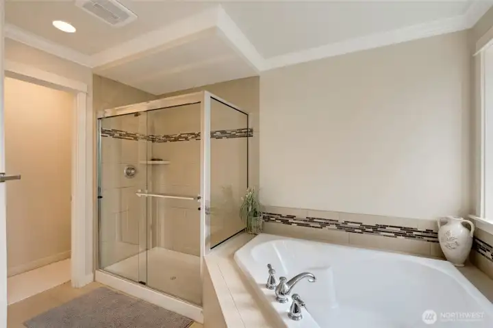 Close-up view of the spa-inspired bath showcasing the deep soaking tub, tiled shower with glass enclosure, and stylish accent trim. A perfect retreat for unwinding at the end of the day.