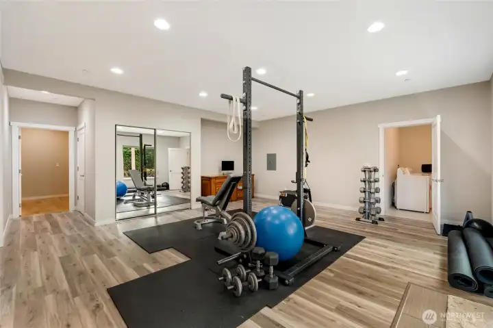 Spacious lower-level fitness area with durable flooring, mirrored wall, and sliding doors to the backyard. Whether used as a home gym, recreation space, or studio, it offers incredible versatility with bright natural light and easy outdoor access.