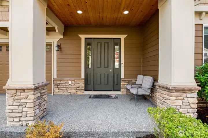 Inviting front entry framed by stone accents and a covered porch, creating a warm first impression and a comfortable spot to sit and unwind.