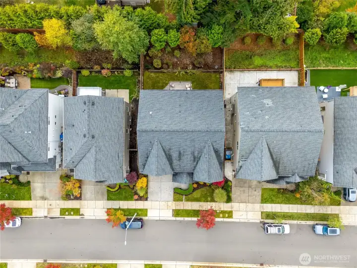 Top-down aerial image outlining the property’s lot and fenced backyard. Highlights proximity to greenbelt space and neighboring homes for context and scale.