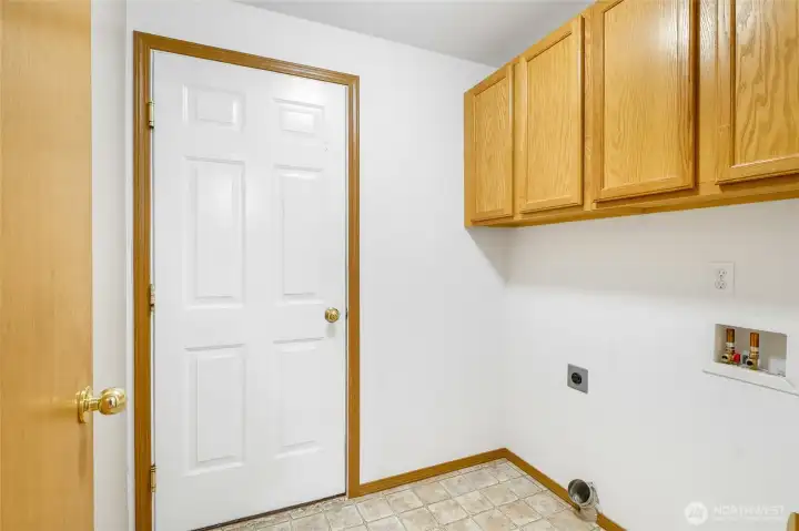 In the laundry room, bring your washer and dryer and enjoy the use of all those upper cabinets! The white door leads into the garage.
