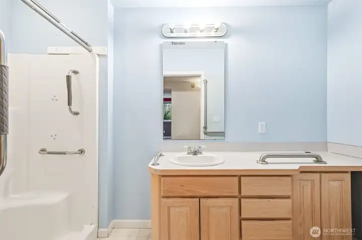 Basement bathroom equipped with safety grab bars throughout