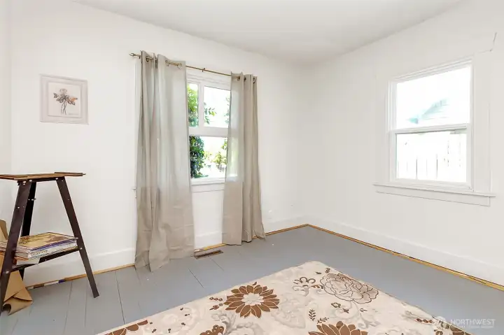 Hardwood floors recently cleaned and painted, this bedroom has a large closet and two windows. Seller will paint room white and this is what it will be looking like with fresh paint.