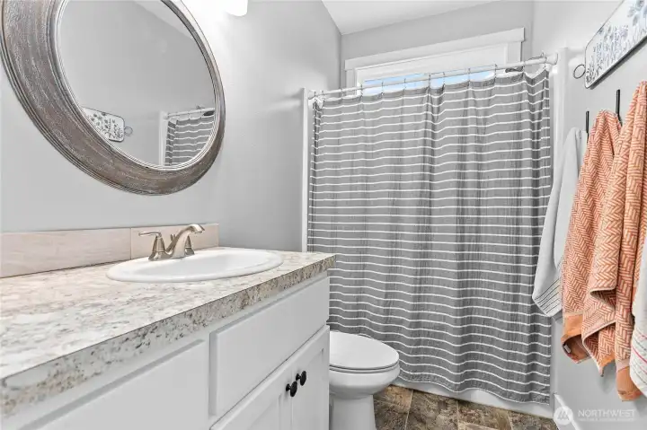 Full size bathroom between bedrooms with extra storage behind door