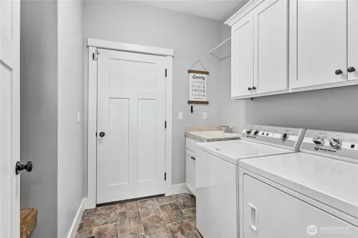 Utility room off kitchen & garage (yes the speed queens are included!!!) with cabinets, large sink & bench/coat rack behind door