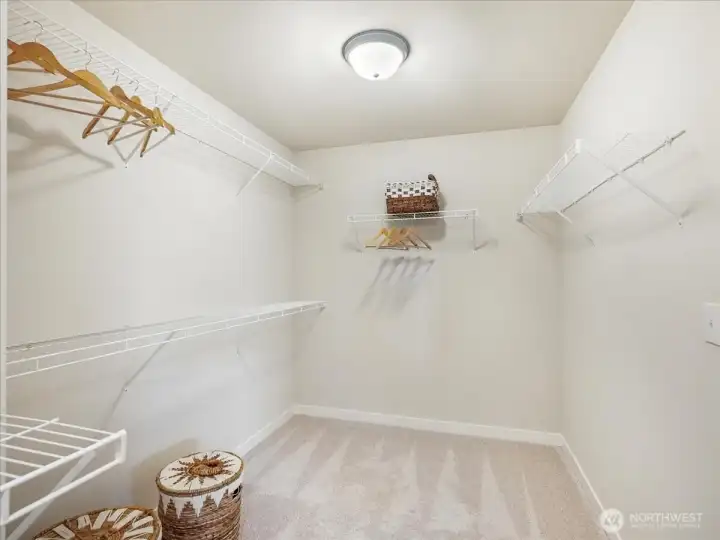 Generous walk-in closet easily accommodates an extensive wardrobe collection.