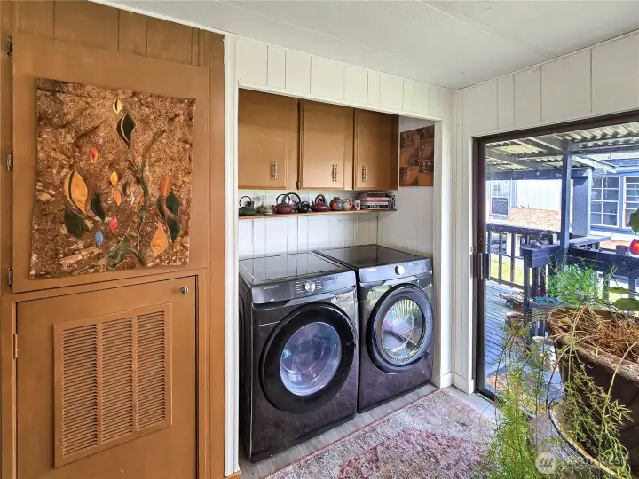 Dedicated laundry area with storage and newer front-load washer and dryer.