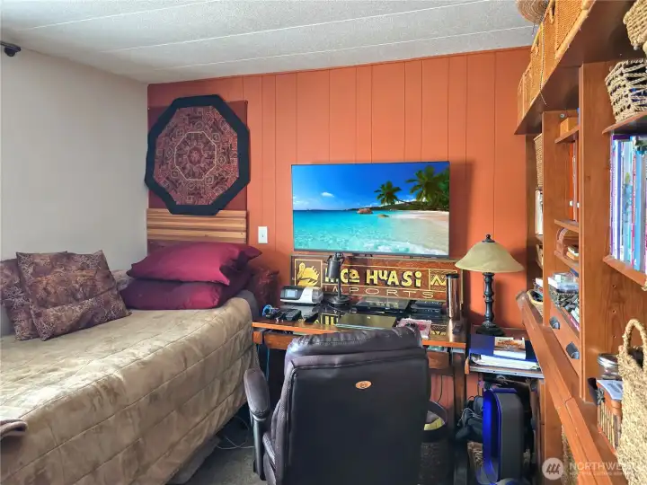 Generously sized second bedroom with access to shared walk-in closet and full wall of storage. The door to the closet is currently blocked by the bed.